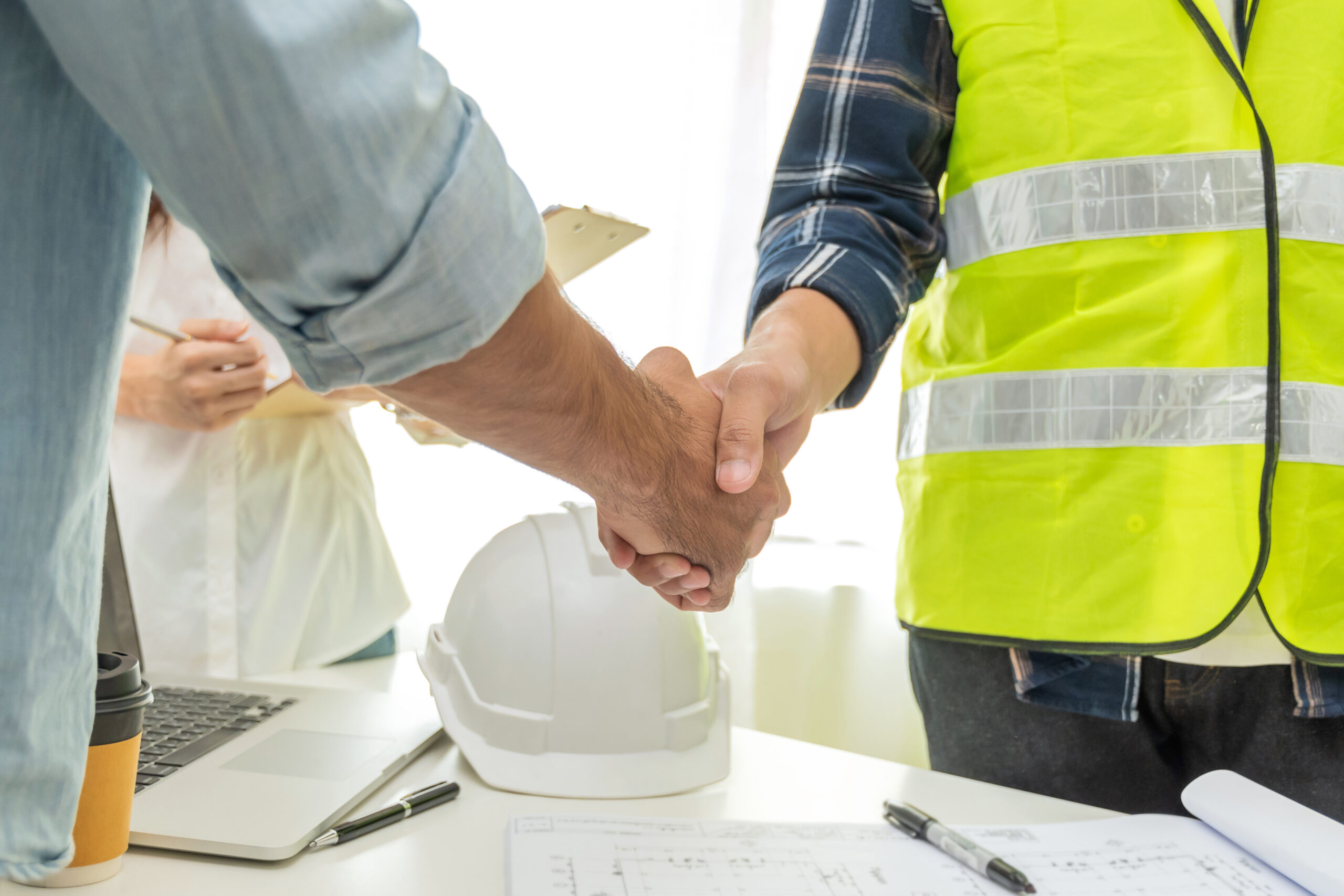 contractor handshake with customer after business meeting start Glada byggarbetar på en byggarbetsplats